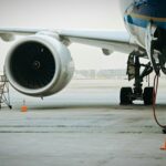 A plane's engine and landing gear are visible.