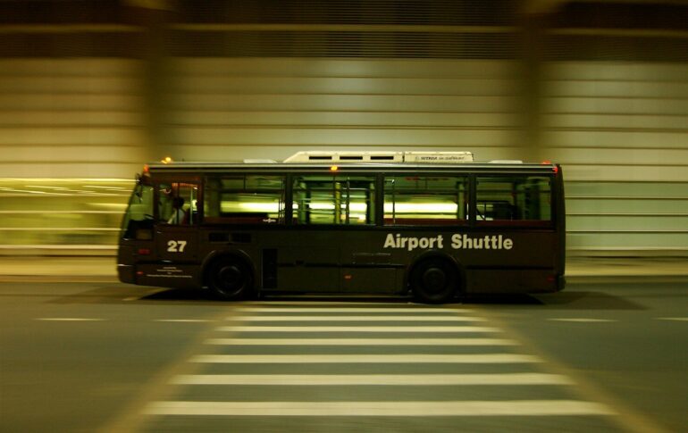 red and black bus on gray road