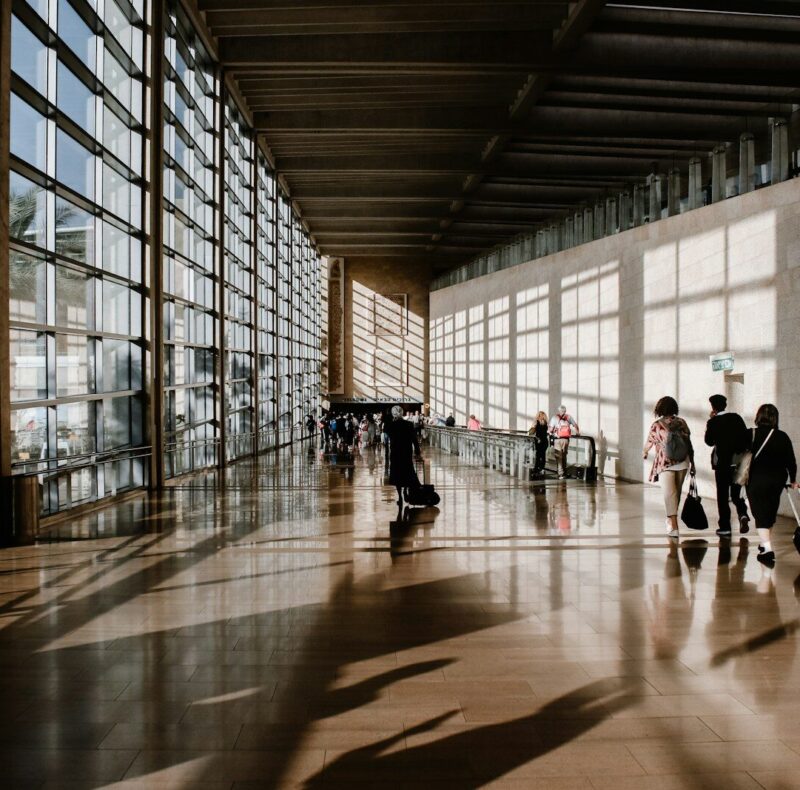 group of people walking beside white building
