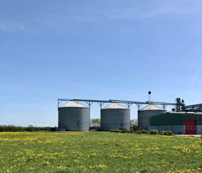 a group of buildings with a field in front of them