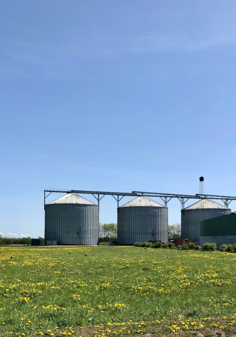 a group of buildings with a field in front of them