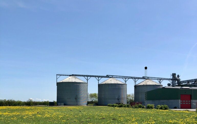 a group of buildings with a field in front of them