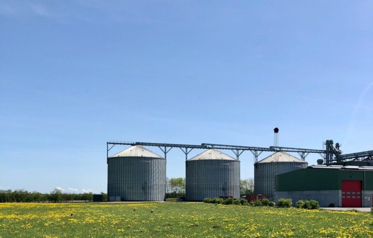 a group of buildings with a field in front of them