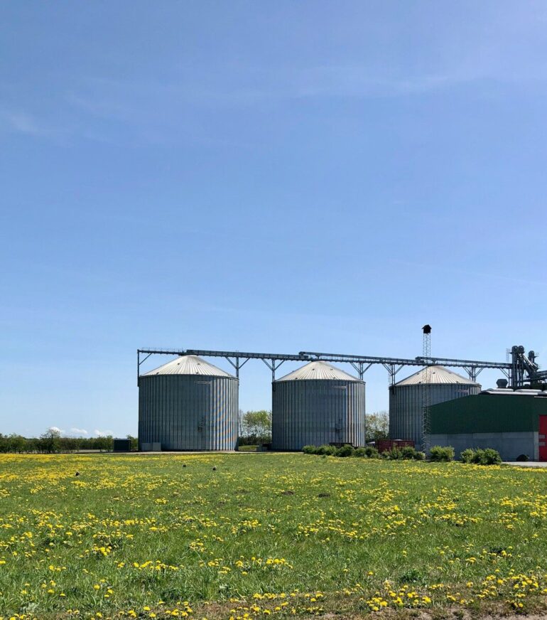 a group of buildings with a field in front of them