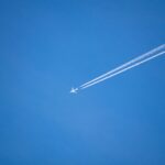 An airplane is flying high in the sky