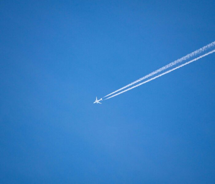 An airplane is flying high in the sky